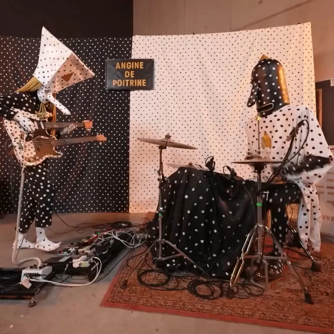 Twee mensen die in een band spelen met bolletjes harnas kleding aan.