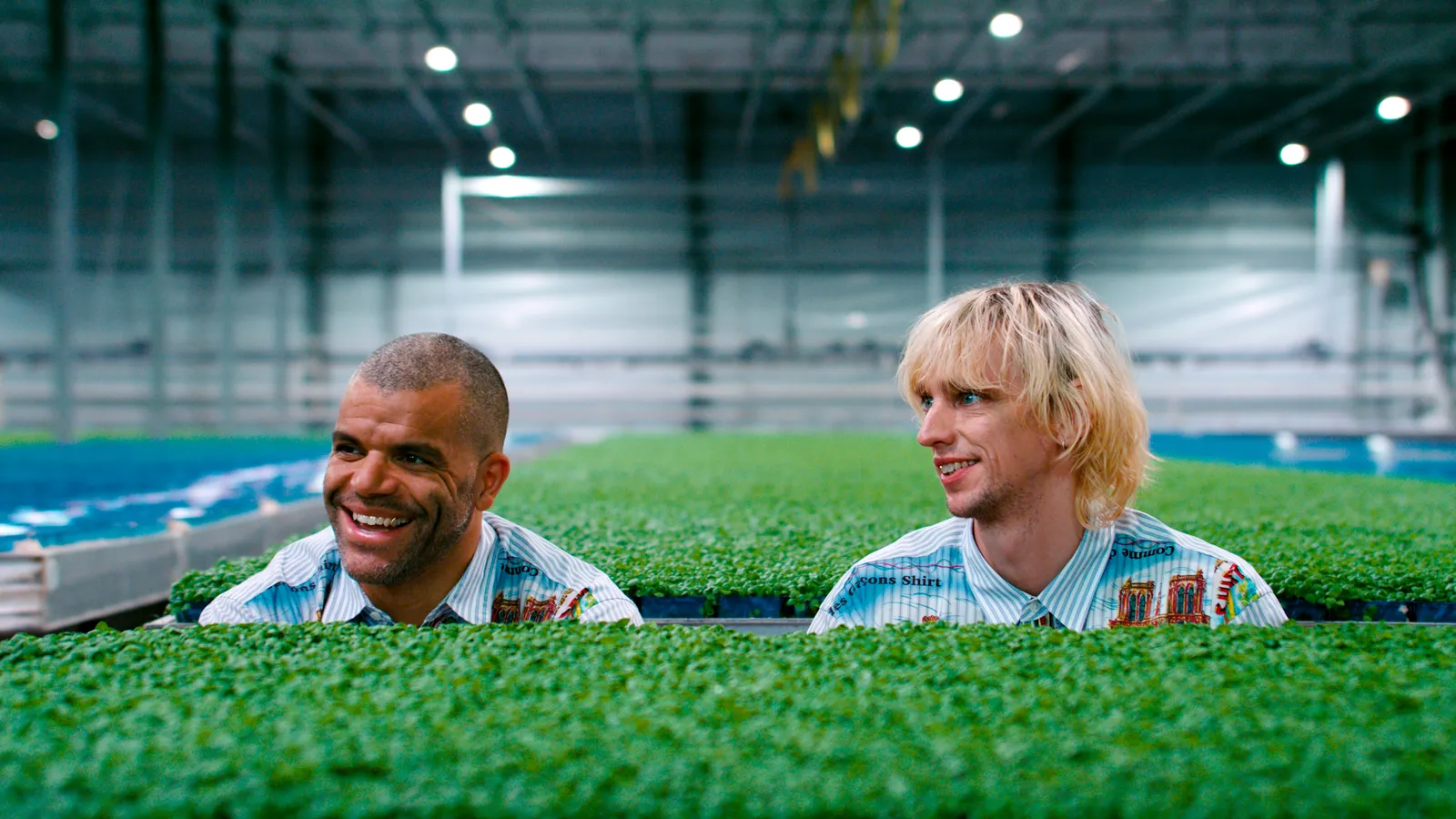 Yousef Gnaoui en Pepijn Lanen kijken naar links terwijl ze in een hal zijn met veel kleine groene plantjes.
