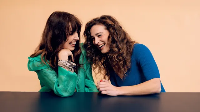 Twee vrouwen, Brankele Frank en Malou Holshuijsen, met bruine haren kijkend schaterlachend naar elkaar