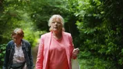 Lies en Joke lopen over een paadje, omringd door groene bomen. Ze kijken om zich heen.