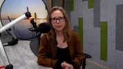 Annette van Soest zit in een radiostudio achter de microfoon, ze kijkt de camera in.