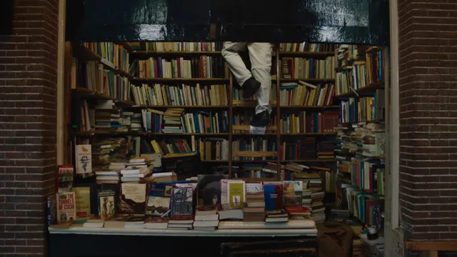 Een boekenkraam waarin een man op een ladder staat