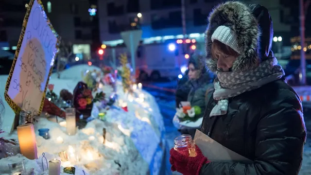 Mensen steken kaarsen aan en leggen bloemen neer bij de moskee in Quebec.