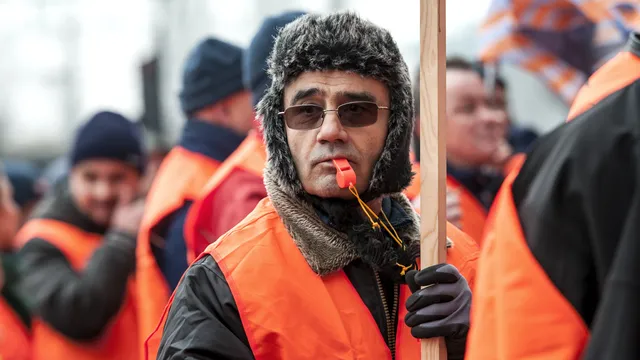 man met muts en fluitje op staking