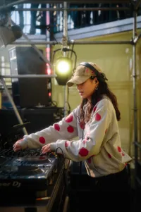 Vrouwelijke dj met een pet op in het zonnetje