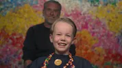 Tex zit in de kappersstoel, hij kijkt lachend richting de camera