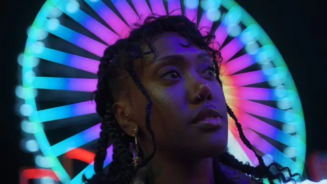 Vrouw die voor kermisattractie staat kijkt voor zich.