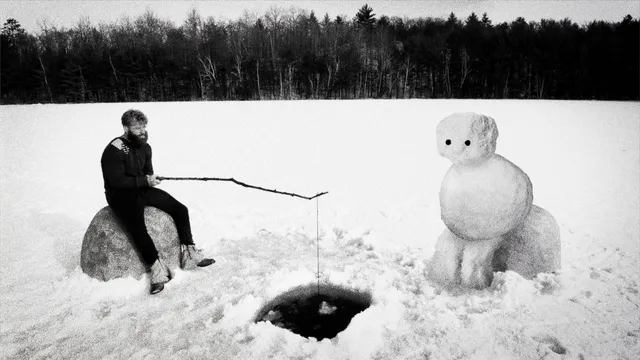 Beeld uit de film Hundreds of Beavers: Een man en een sneeuwpop vissen in een besneeuwde omgeving