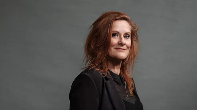 Lotje IJzermans kijkt naar de camera voor een grijze achtergrond.