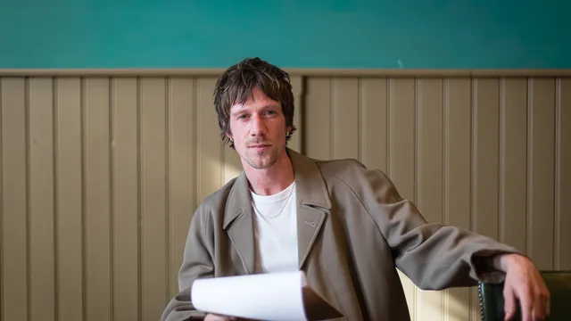 Man met menukaart in hand kijkt in de camera