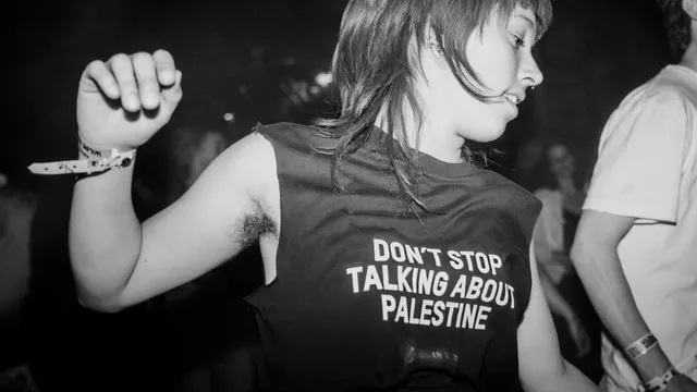 meisje dat danst op punkmuziek en op haar shirt staat don't stop talking about palastine