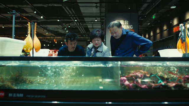 Pete Wu staat bij een aquarium met zijn ouders