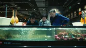 Pete Wu staat bij een aquarium met zijn ouders