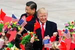 De president van de Verenigde Staten en de partijleider van China lopen tussen kinderen die Chinese en Amerikaanse vlaggetjes en bloemen omhooghouden.