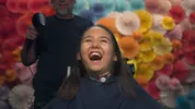 Sienna zit in de kappersstoel, ze lacht hard
