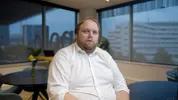 Willem Westerhof zit, hij kijkt richting de camera