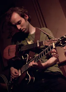 De met instrumenten behangen gitarist en backing vocalist Steven Roeters