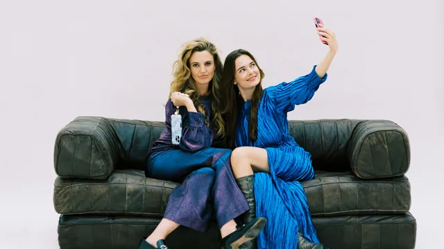 Vera en Simoon zitten samen op de bank. Simoon maakt een selfie, terwijl Vera de camera in kijkt.