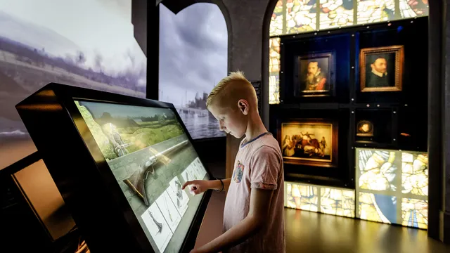 Jongen kijkt naar canon van Nederland in het Openluchtmuseum