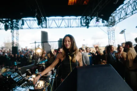 Vrouw met ogen dicht draait muziek in de dj booth