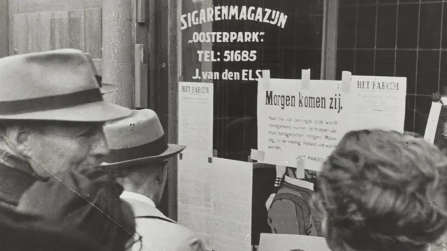 Amsterdammers kijken naar een gestencilde Parool in 1945