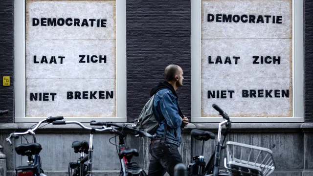 Democratie laat zich niet breken staat er op de dichtgetimmerde ramen van het partijkantoor van D66.