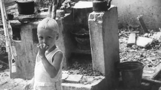 Zwart wit foto van een nederlands jongetje in een van de Japanse kampen