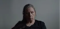 Een vrouw kijkt droevig naar beneden.