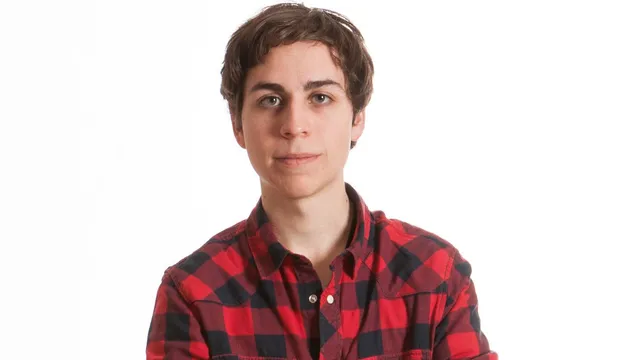 Een jongen in een geruite blouse voor een witte achtergrond.