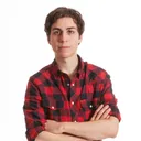 Een jongen in een geruite blouse voor een witte achtergrond.