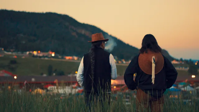 Julian Brave NoiseCat and his father Ed Archie NoiseCat look down at the Williams Lake Stampede from the top of "Indian Hill" on their roadtrip back to St. Joseph's Mission, where Ed was born. (Credit: Emily Kassie/Sugarcane Film LLC)