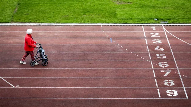 Een deelnemer aan de Nationale Rollatorloop 2024 in het Olympisch Stadion in Amsterdam. Het evenement is bedoeld om het fysieke en mentale welzijn van ouderen te bevorderen.