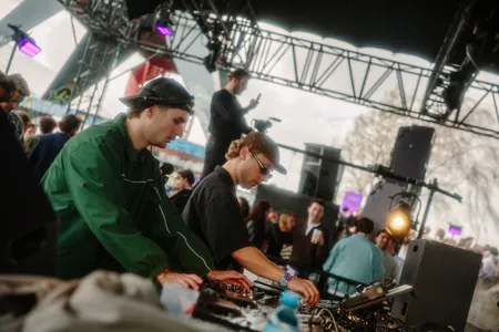 Twee jongens met petten op in de dj-booth