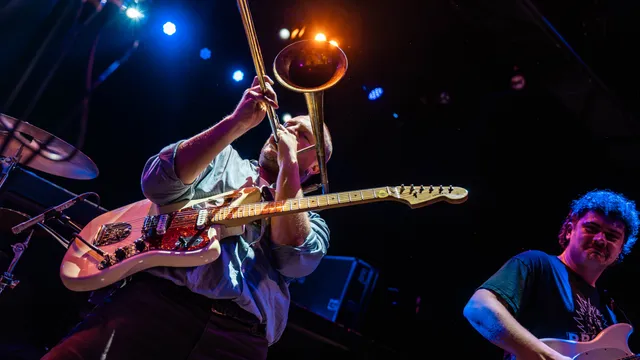 Foto van man met gitarist die trombone speelt