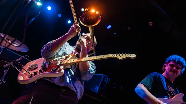 Foto van man met gitarist die trombone speelt