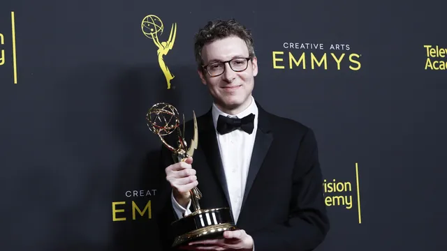 Componist Nicholas Britell gekleed in een zwarte smoking toont vol trots zijn Emmy award