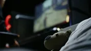 Een teddybeer zit op de voorgrond, op de achtergrond een computerscherm
