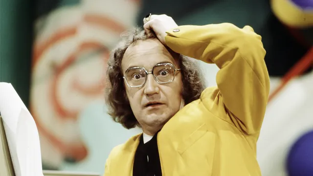 IJf Blokker als Fred Servet kijkt verbaasd in de camera met een hand op zijn hoofd