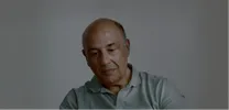 Een man kijkt droevig naar beneden.