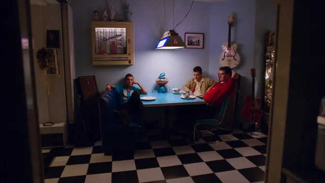 De jongens uit Rockabilly baby zitten aan een tafel