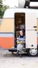 Bibi zit in de deuropening van de caravan