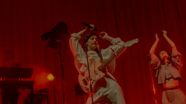 Eefje de visser met microfoon en gitaar aan het optreden