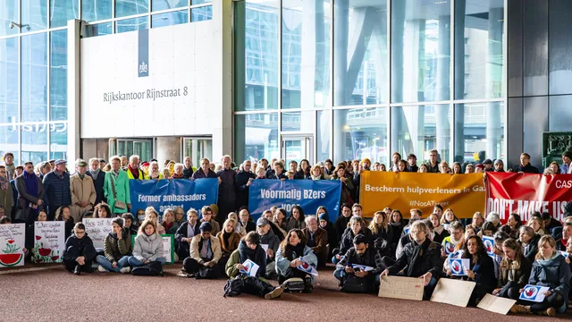 Een groep (oud)amtenaren houdt een sit-in voor Gaza voor het Ministerie van Buitenlandse Zaken. Ze houden protestborden vast.