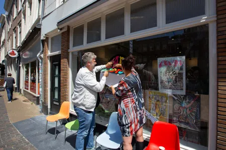 De eigenaren van platenzaak Variaworld aan de Oudegracht plakken de laatste stickers op de winkelruit.