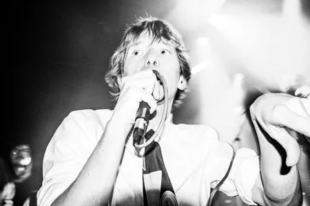 Lead vocalist van Grote Geelstaart. Hij is dichtbij de camera en het is in het zwart-wit.