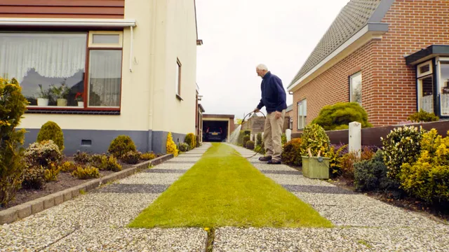 Man sproeit grasstrookje