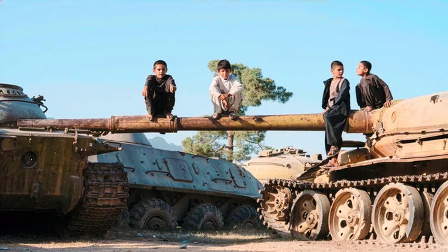 Foto van kinderen die op tanks zitten in Kaboel