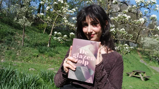 Naaz houdt het boek 'De glazen stolp' vast. Ze glimlacht.