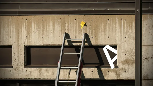 Afbeelding van een ladder tegen een muur.