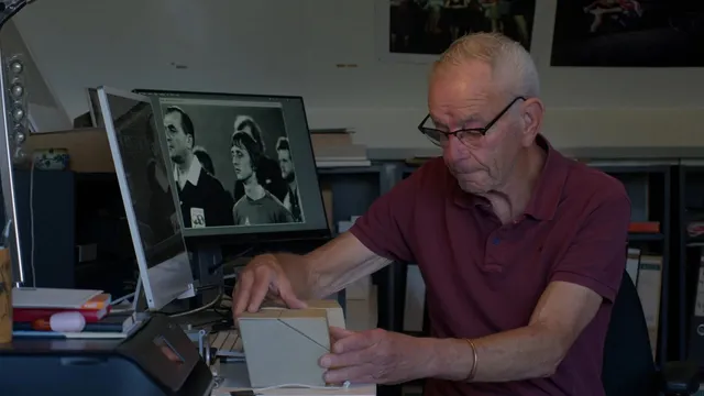 Een man in een polo bladert door documenten.